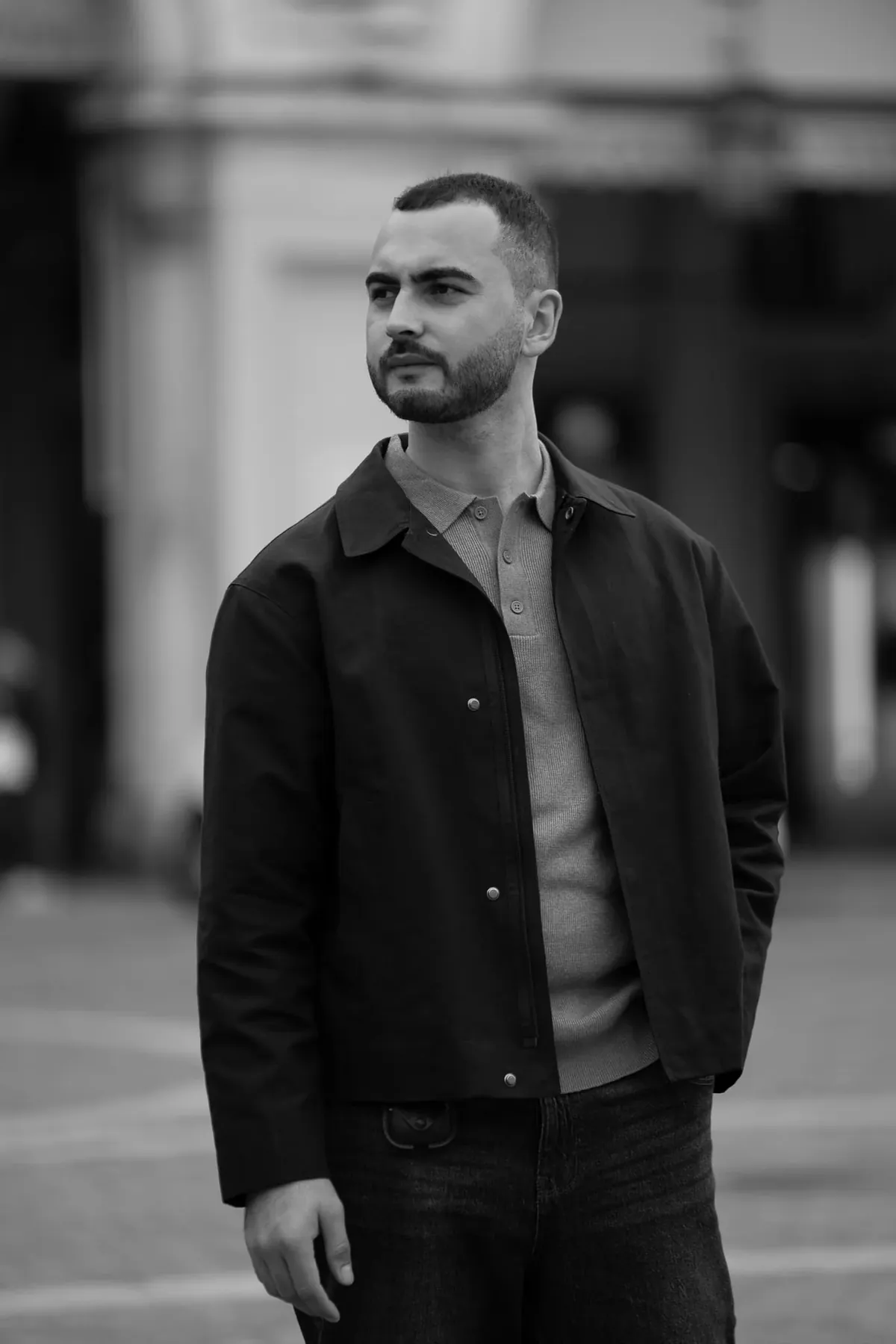 Toghrul Nabi, wedding photographer and filmmaker, standing in a street in a dark jacket, black and white