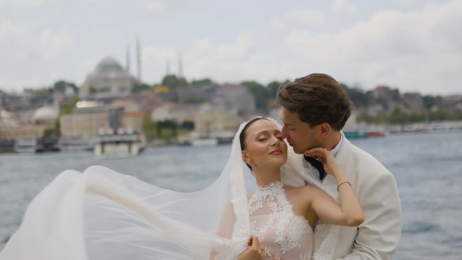 A still from Gül and Oğuz's wedding film in Istanbul: her veil sweeping in the wind by the water