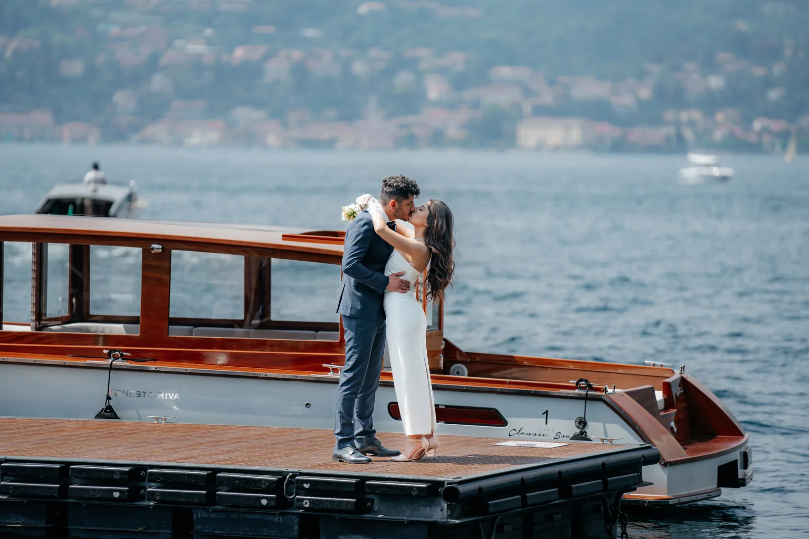 Un bacio su un pontile accanto a un motoscafo d'epoca in legno sul Lago di Como (non a Villa Cortine)
