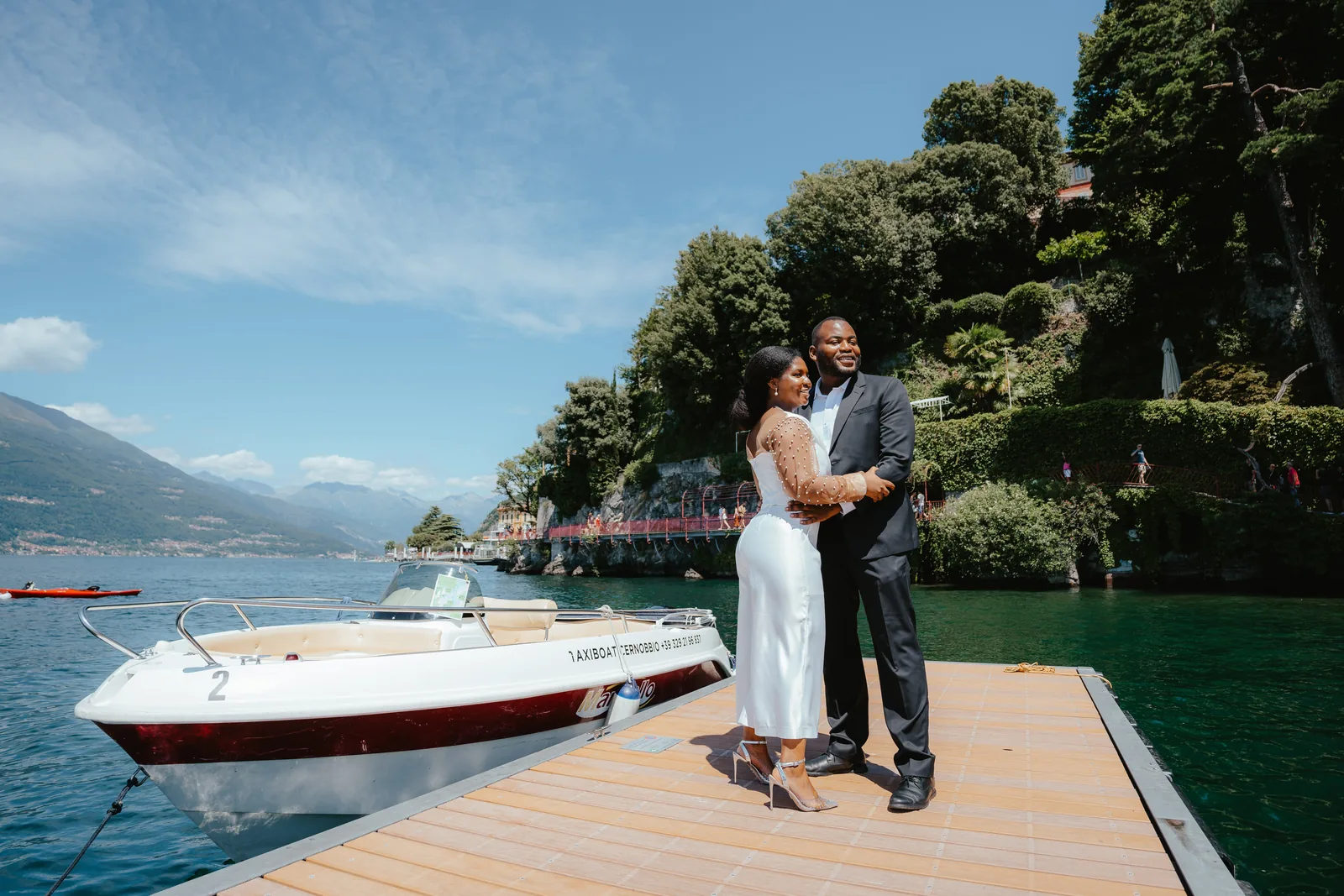 A couple on a jetty beside a water taxi, elsewhere on Lake Como (not at Villa Sola Cabiati)
