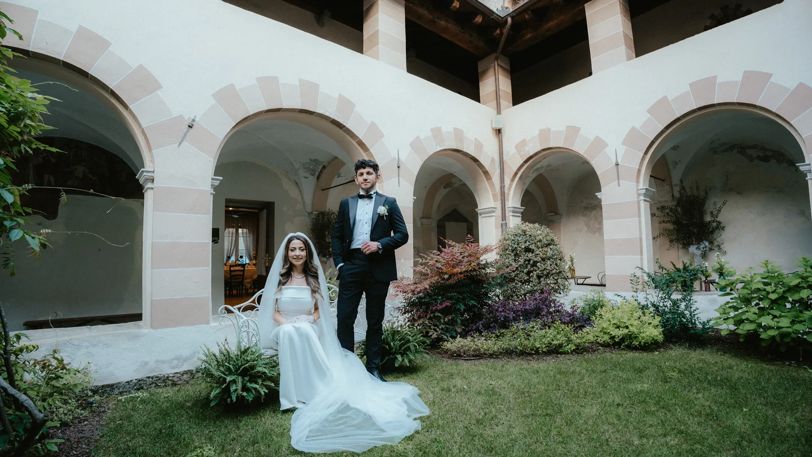 Musa and Solmaz in an arcaded courtyard garden in Susa, Piedmont, during their pre-wedding session
