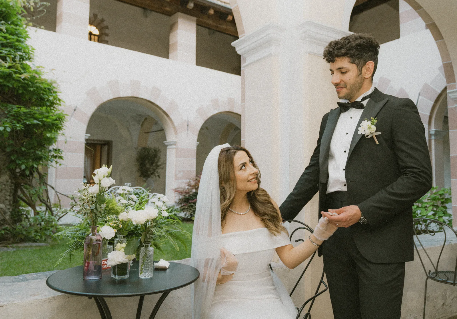 Musa and Solmaz hand in hand in a courtyard in Susa, Piedmont (not at the Castello di Govone)